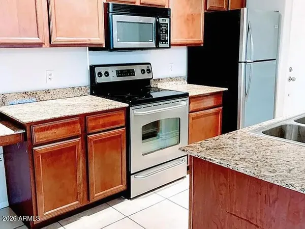 a kitchen with granite countertop cabinets stainless steel appliances and wooden cabinets