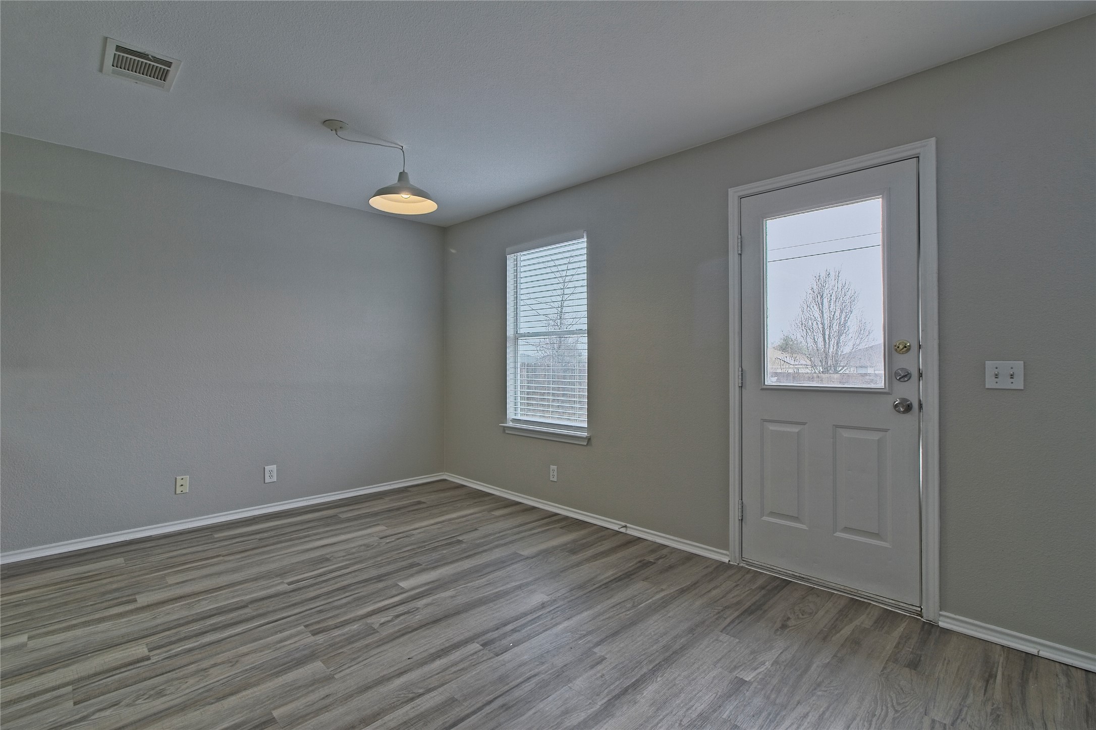 232 Brickyard Lane Jarrell, TX 76537 - Photo 11 of 31 Laminate flooring extends into this bright room, complemented by a window and glass-paned door.