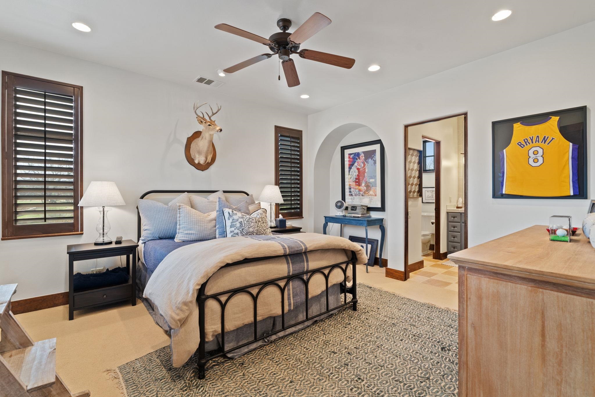 119 Plaza Escondido Horseshoe Bay, TX 78657 - Photo 20 of 30 a bedroom with a bed and a chandelier