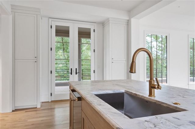 an empty room with wooden floor windows and front door
