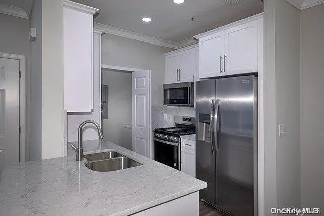 a kitchen with a refrigerator sink and cabinets