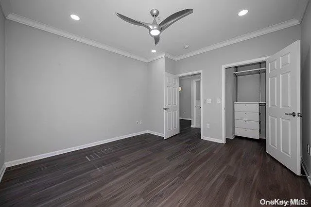 an empty room with wooden floor and ceiling fan