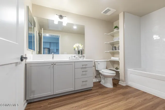 a bathroom with a toilet a sink and mirror