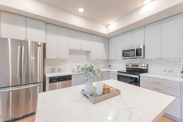 a kitchen with stainless steel appliances a refrigerator sink stove microwave and cabinets