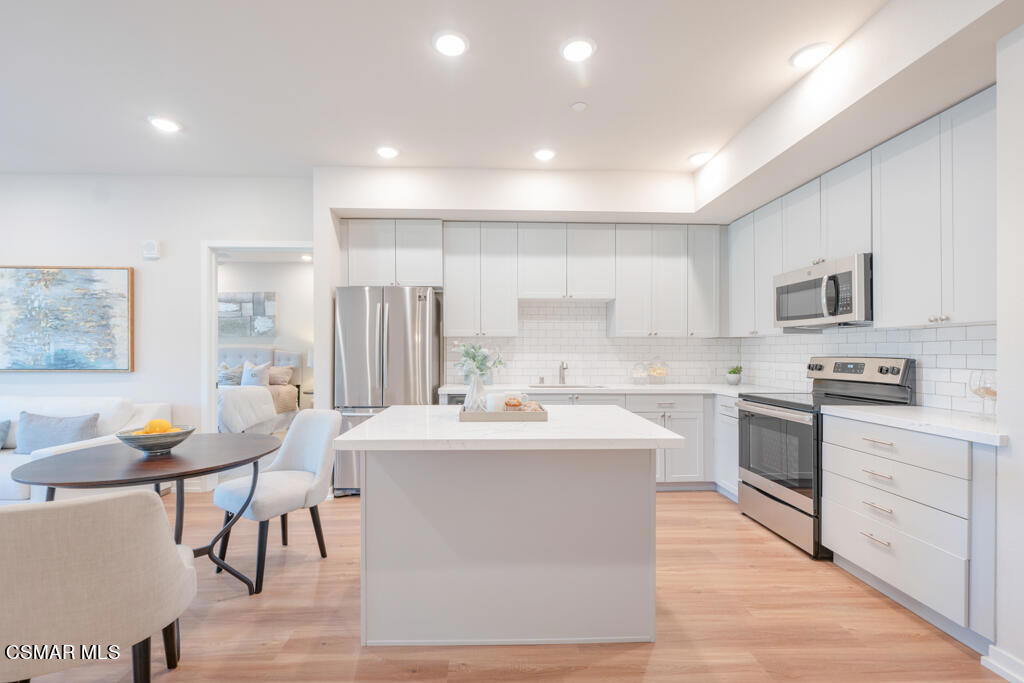 77 North Conejo School Road, Unit 208 Thousand Oaks, CA 91362 - Photo 6 of 27 a kitchen with stainless steel appliances kitchen island granite countertop a sink and cabinets