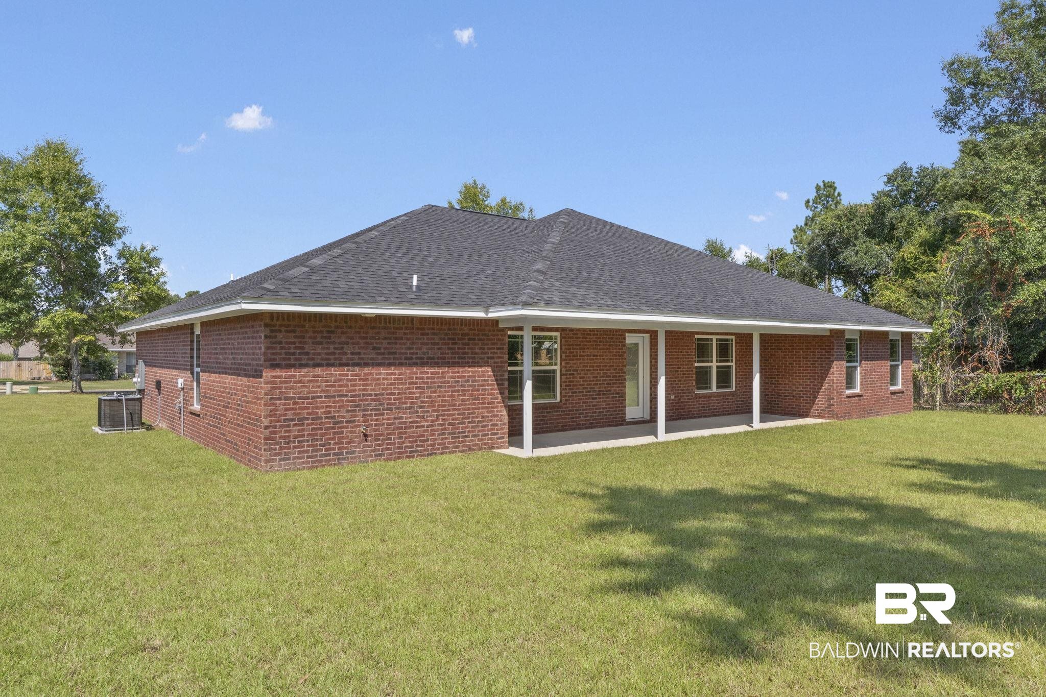 32563 Arbor Ridge Circle Lillian, AL 36549 - Photo 35 of 53 Back of house featuring brick siding, a lawn, and a patio area