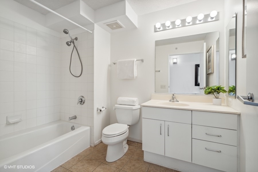 800 Elgin Road, Unit 1304 Evanston, IL 60201 - Photo 14 of 18 a bathroom with a granite countertop sink a toilet and a mirror