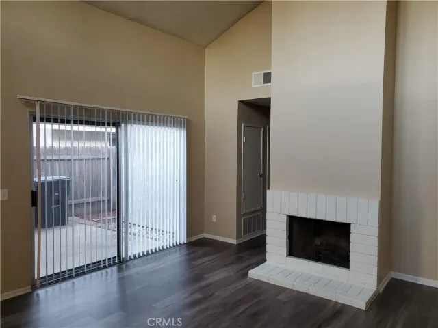 a view of a livingroom with wooden floor and a fireplace