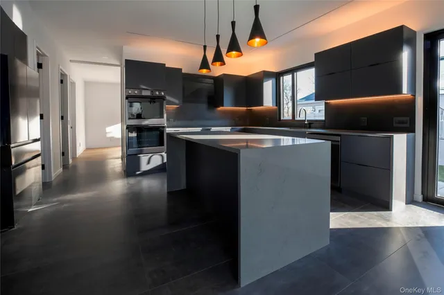 a kitchen with stainless steel appliances kitchen island a stove and a refrigerator