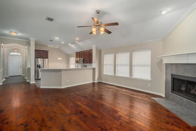 a view of empty room with wooden floor and fireplace