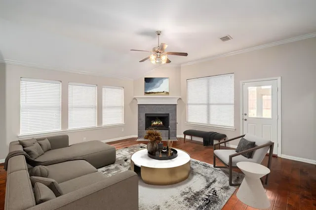 a living room with furniture a fireplace and a large window
