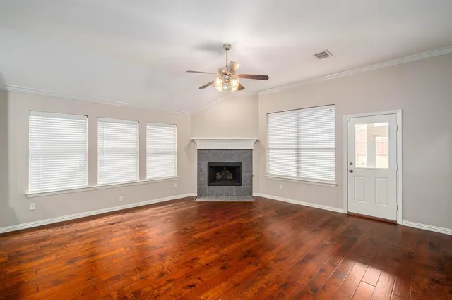 wooden floor fireplace and windows in an empty room