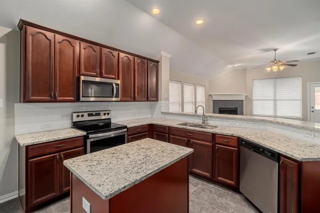 a kitchen with a stove a sink a microwave and wooden cabinets