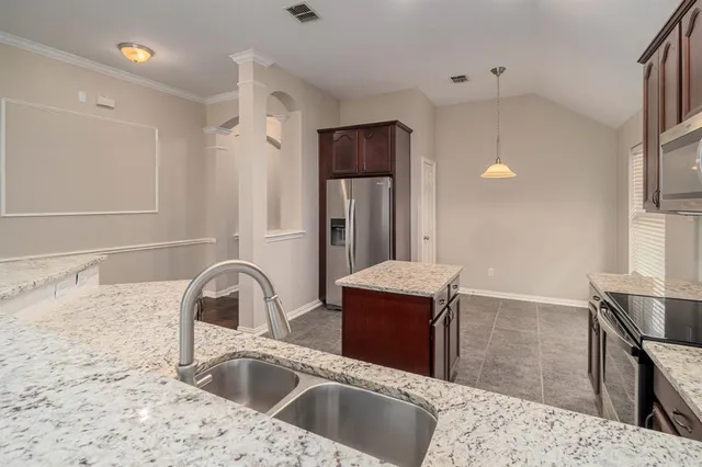 a kitchen with stainless steel appliances granite countertop a sink and a refrigerator
