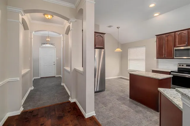 a kitchen with a refrigerator and a stove top oven