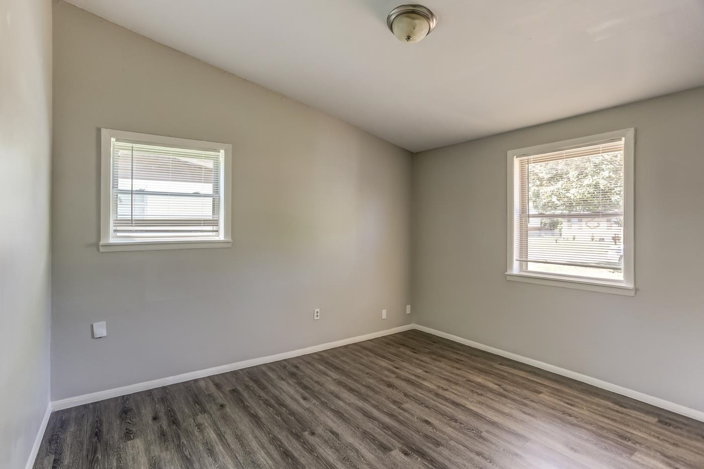 4566 Applegate Road Memphis, TN 38109 - Photo 11 of 25 an empty room with wooden floor and windows