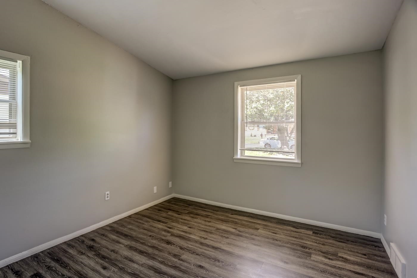 4566 Applegate Road Memphis, TN 38109 - Photo 12 of 25 an empty room with wooden floor and windows