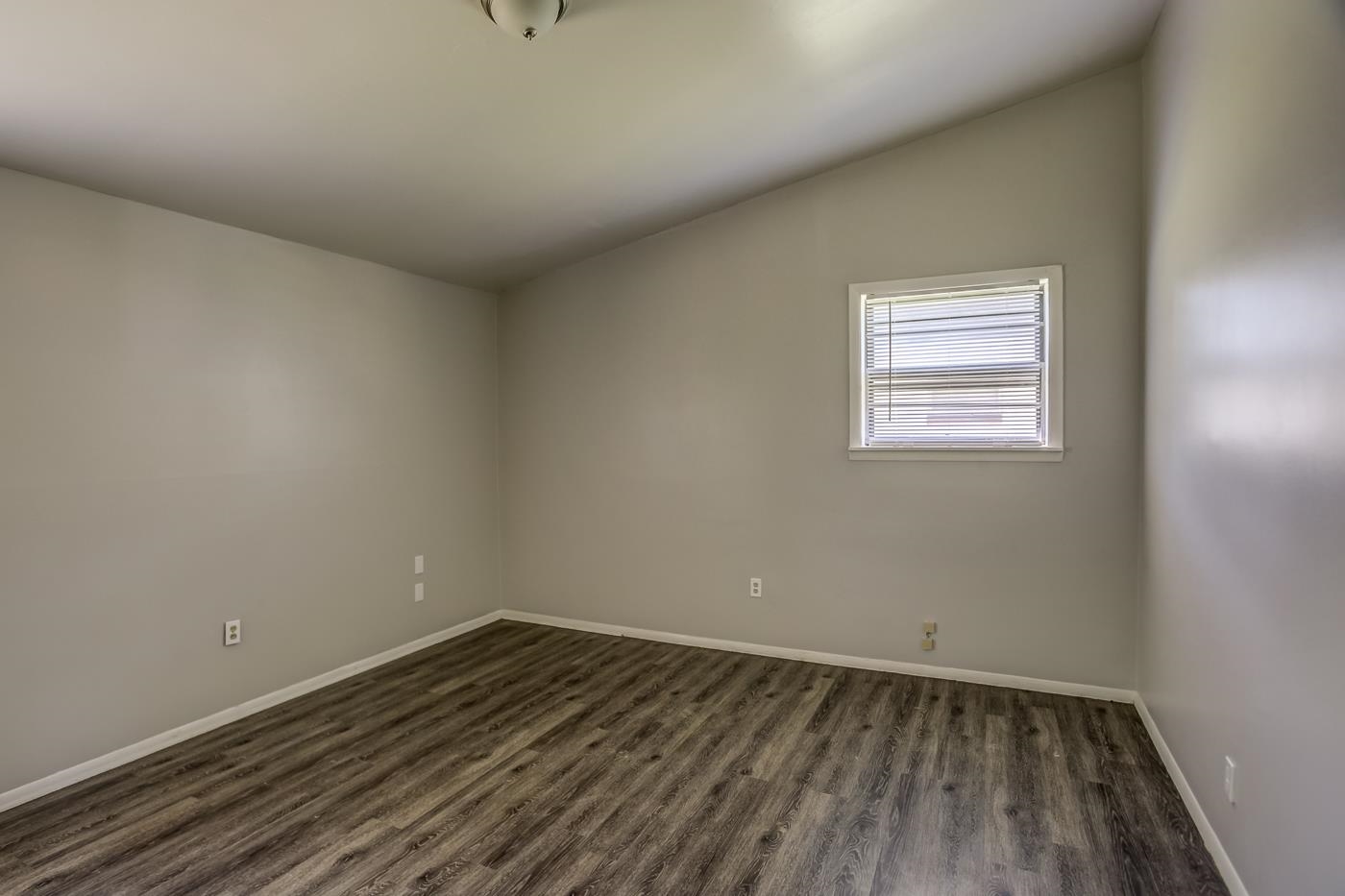 4566 Applegate Road Memphis, TN 38109 - Photo 15 of 25 an empty room with wooden floor and windows