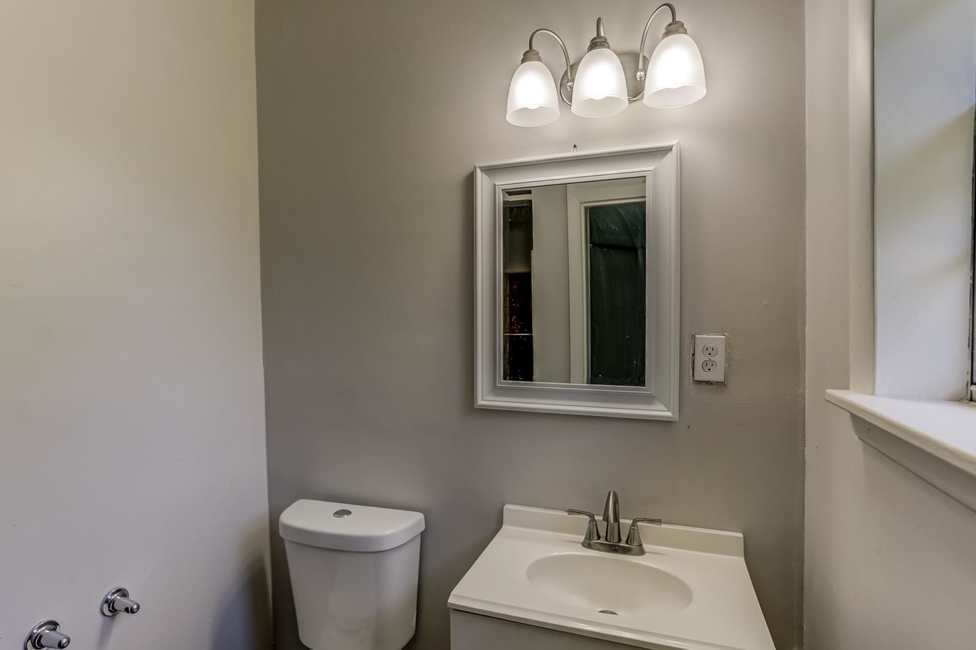 4566 Applegate Road Memphis, TN 38109 - Photo 19 of 25 a bathroom with a toilet sink and mirror