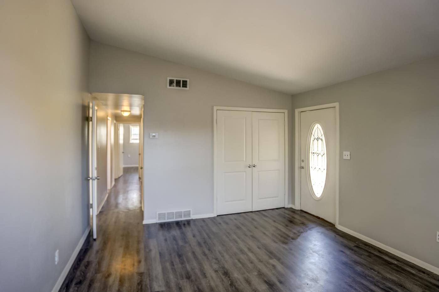 4566 Applegate Road Memphis, TN 38109 - Photo 2 of 25 an empty room with wooden floor and windows