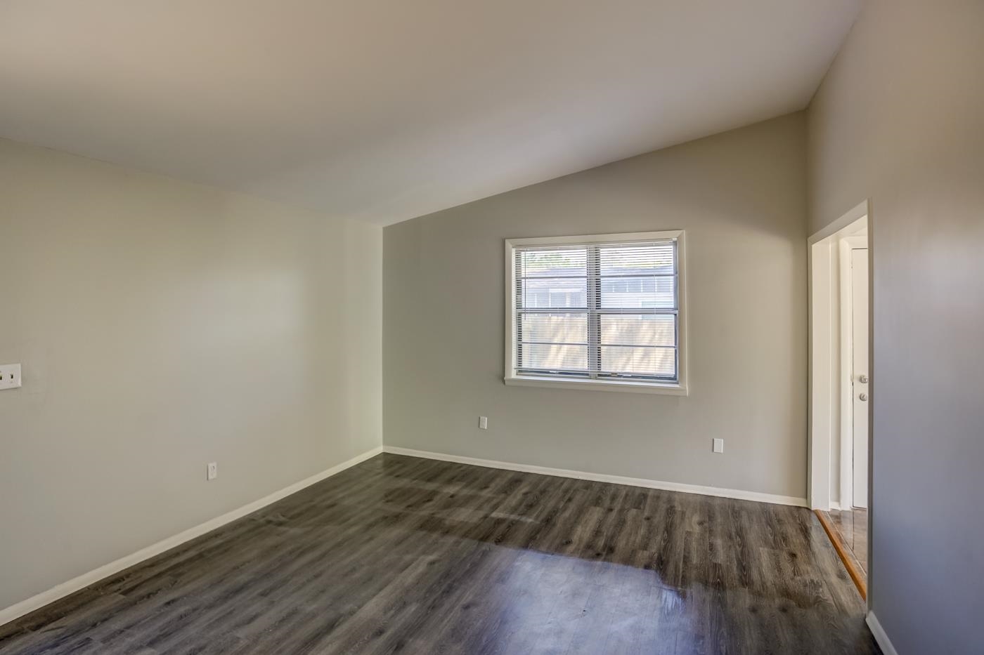 4566 Applegate Road Memphis, TN 38109 - Photo 4 of 25 an empty room with wooden floor and windows