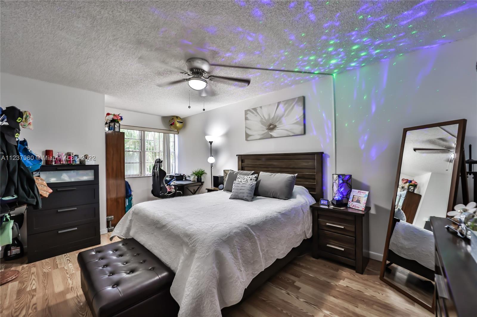 6902 North Kendall Drive, Unit E203 Pinecrest, FL 33156 - Photo 5 of 12 a bedroom with a bed a mirror and dresser