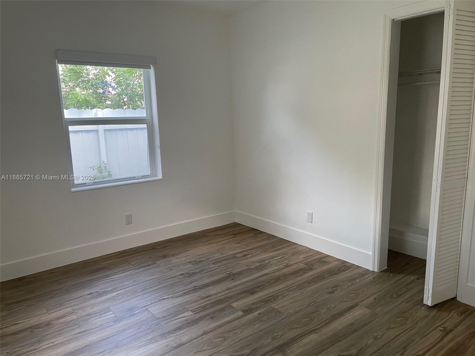 2434 Coolidge Street, Unit FRONT Hollywood, FL 33020 - Photo 12 of 18 an empty room with wooden floor and windows