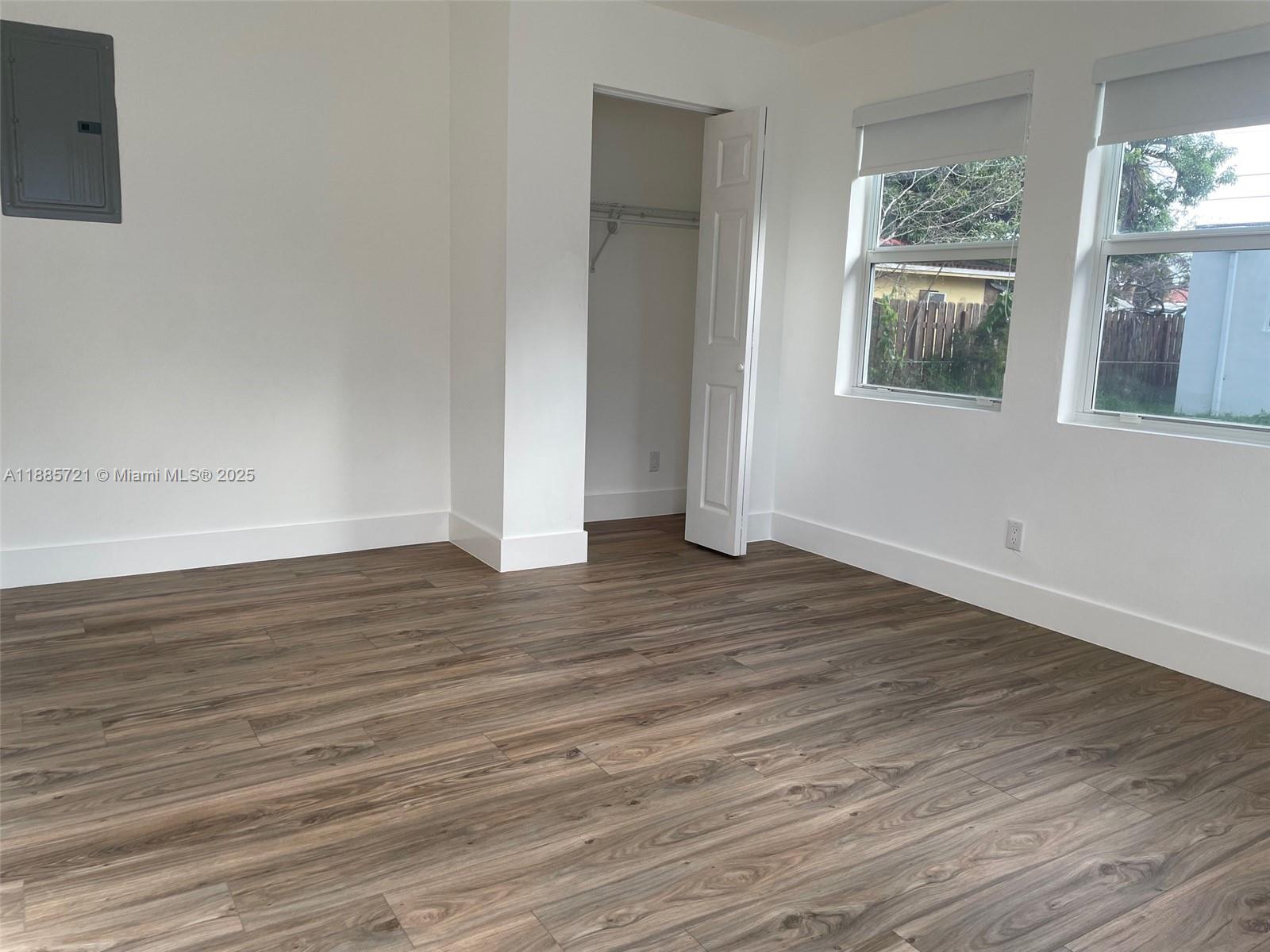 2434 Coolidge Street, Unit FRONT Hollywood, FL 33020 - Photo 14 of 18 a view of an empty room with wooden floor and a window