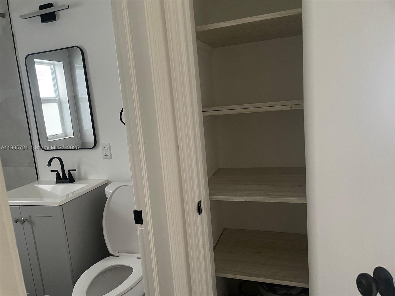 2434 Coolidge Street, Unit FRONT Hollywood, FL 33020 - Photo 15 of 18 a bathroom with a toilet sink and mirror