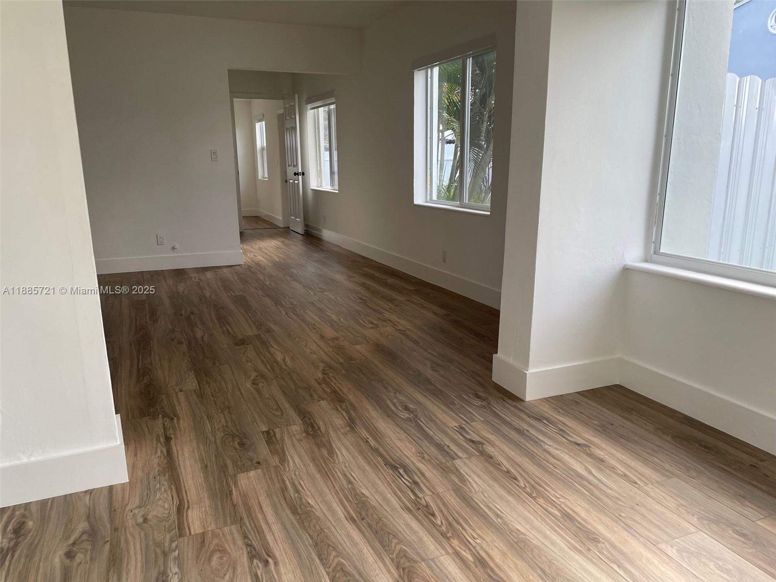 2434 Coolidge Street, Unit FRONT Hollywood, FL 33020 - Photo 5 of 18 an empty room with wooden floor and windows