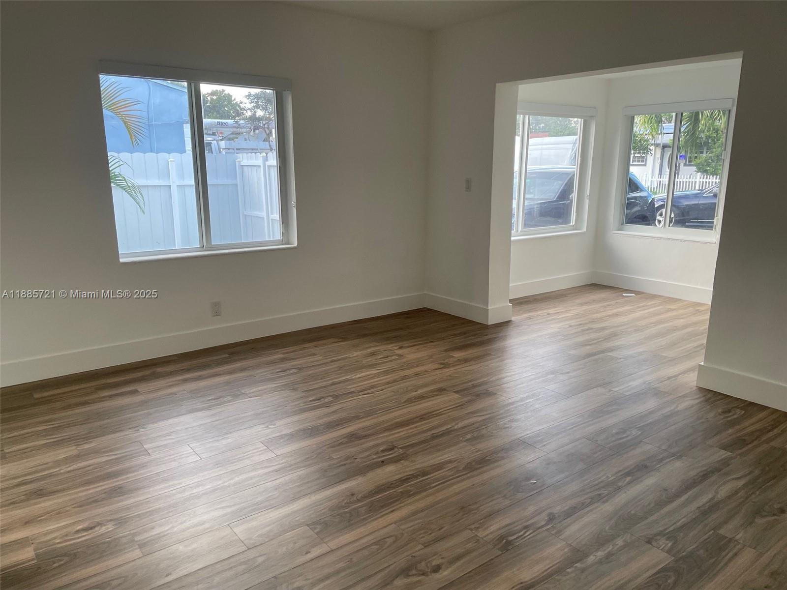 2434 Coolidge Street, Unit FRONT Hollywood, FL 33020 - Photo 6 of 18 an empty room with wooden floor and windows