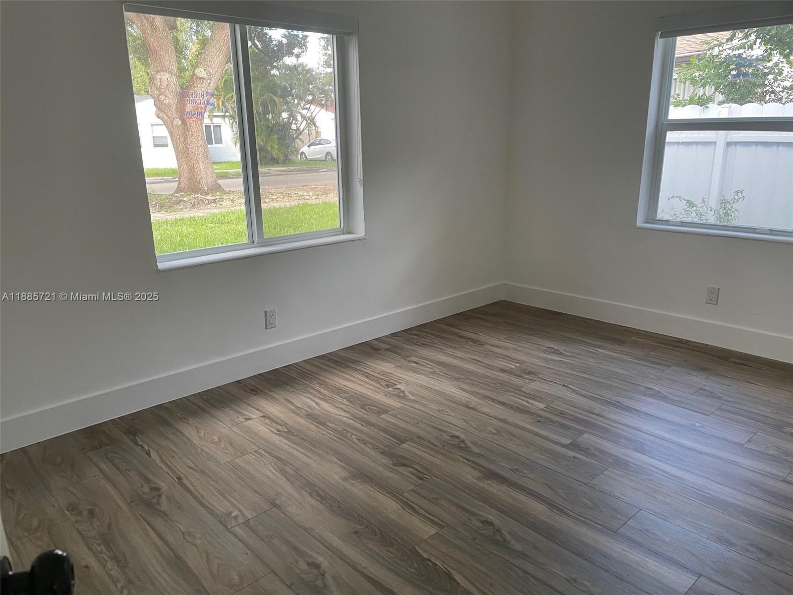 2434 Coolidge Street, Unit FRONT Hollywood, FL 33020 - Photo 7 of 18 an empty room with wooden floor and windows