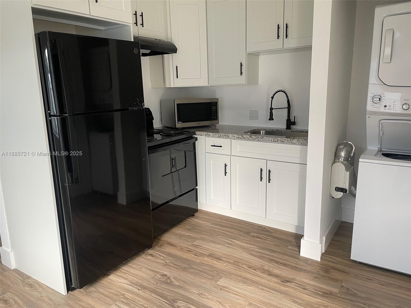 2434 Coolidge Street, Unit FRONT Hollywood, FL 33020 - Photo 9 of 18 a kitchen with a refrigerator sink and cabinets