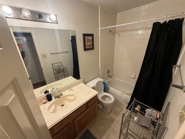 a bathroom with a sink a toilet a mirror and shower
