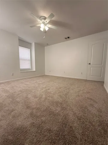 an empty room with chandelier fan
