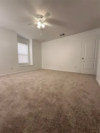a view of an empty room with a ceiling fan
