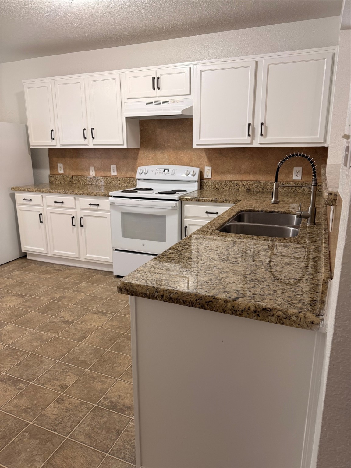19410 Bold River Road Tomball, TX 77375 - Photo 20 of 25 a kitchen with granite countertop a sink a stove and cabinets