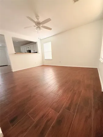an empty room with a ceiling fan and window