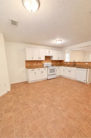 a large white kitchen with cabinets