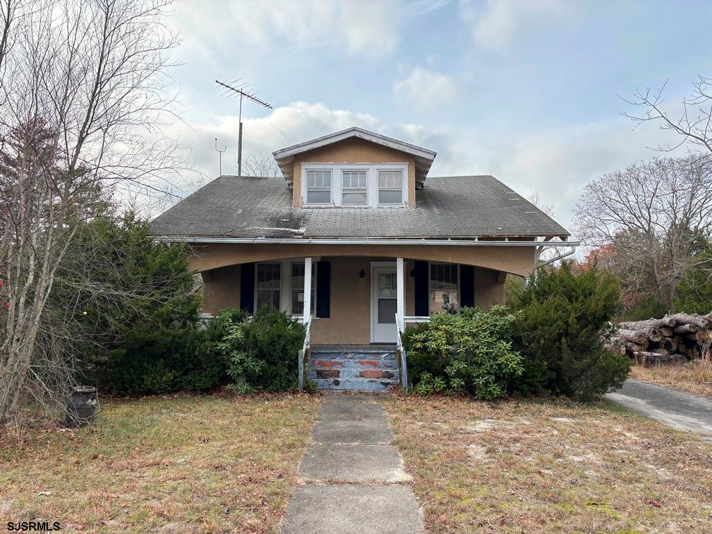 a front view of house with yard and trees around