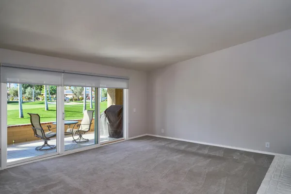 a view of an empty room with wooden floor and sliding glass door