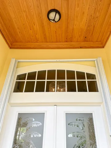 a kitchen with stainless steel appliances kitchen island granite countertop a dining table chairs and a refrigerator