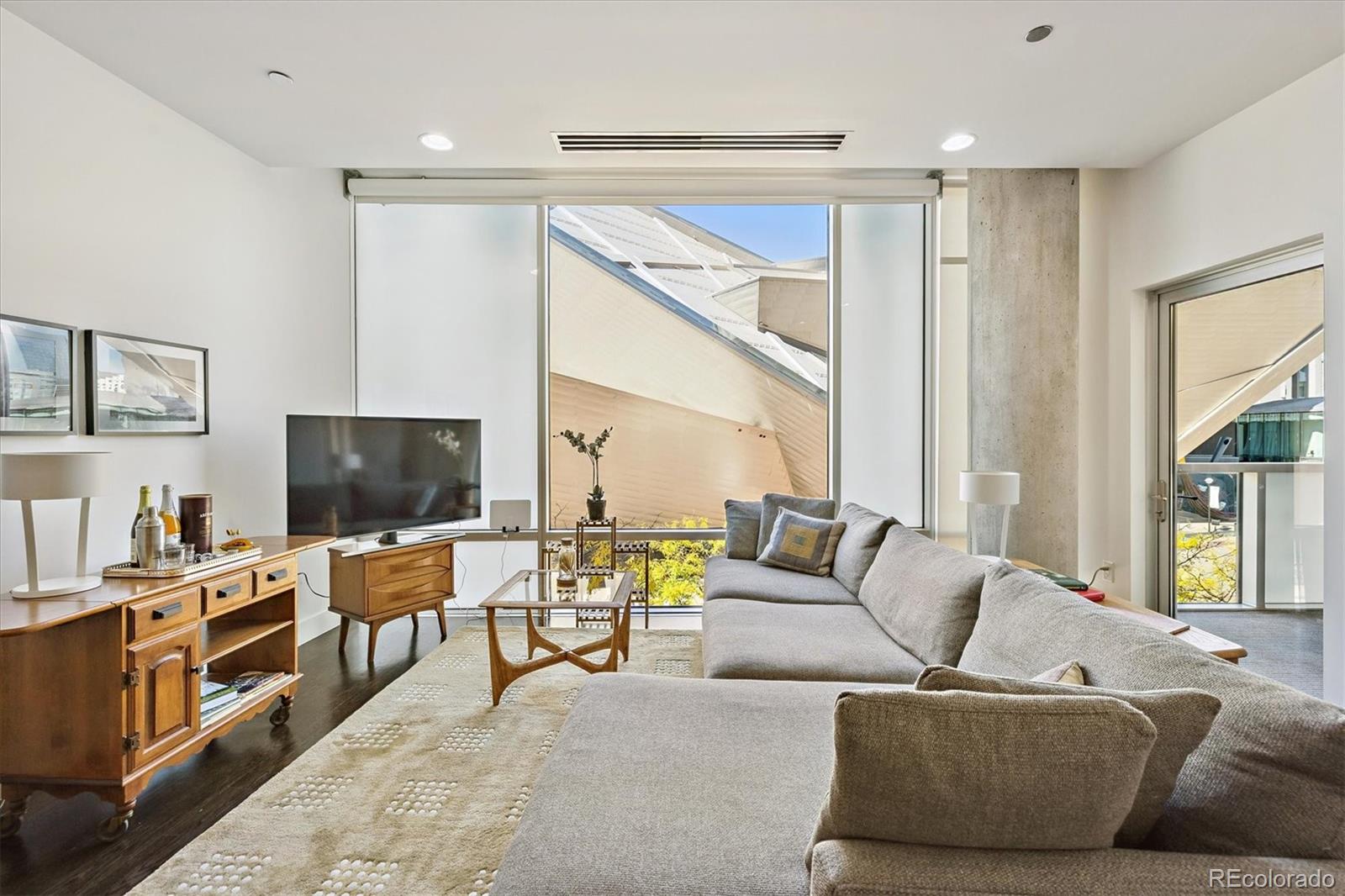 1200 Acoma Street, Unit 303 Denver, CO 80204 - Photo 1 of 48 a living room with furniture and a flat screen tv