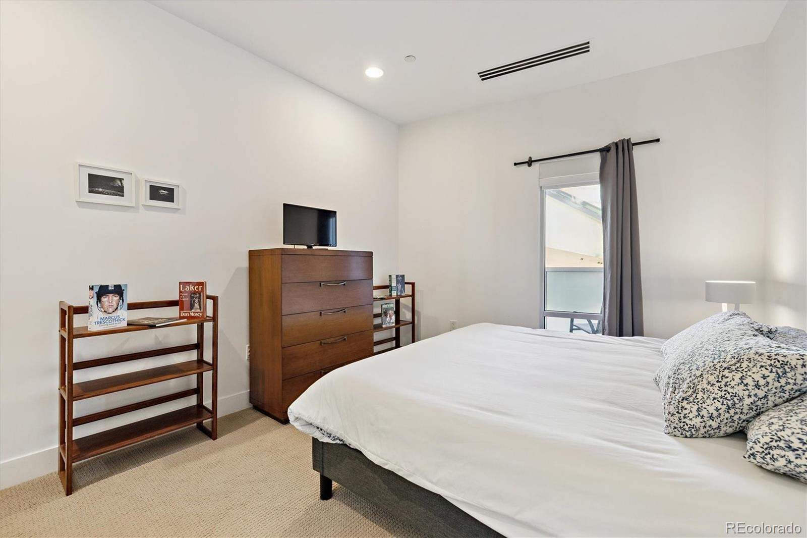 1200 Acoma Street, Unit 303 Denver, CO 80204 - Photo 17 of 48 a bedroom with a bed and a television