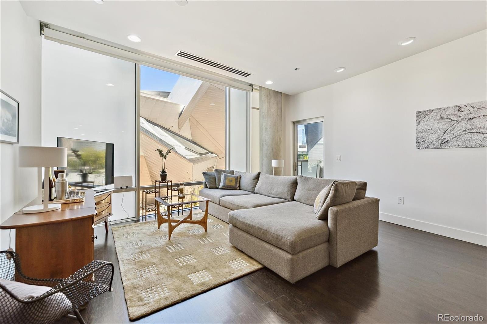1200 Acoma Street, Unit 303 Denver, CO 80204 - Photo 2 of 48 a living room with furniture and wooden floor