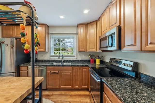 a kitchen with stainless steel appliances granite countertop a stove a sink and a microwave
