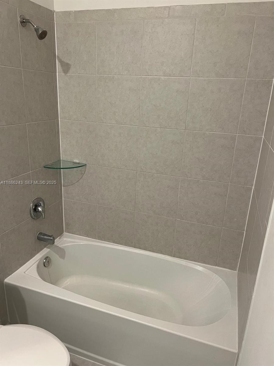 26413 Southwest 149th Avenue, Unit 26413 Homestead, FL 33032 - Photo 16 of 29 a white bath tub sitting next to a white toilet