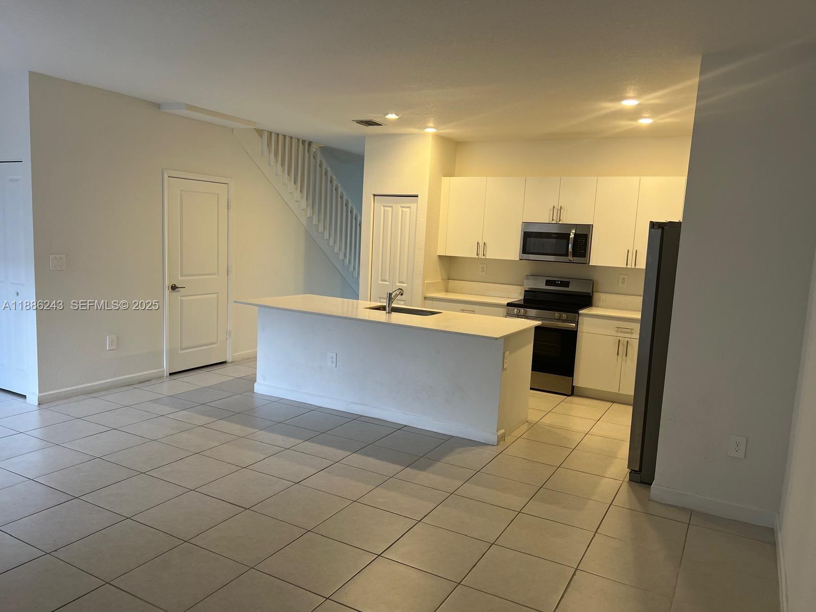 26413 Southwest 149th Avenue, Unit 26413 Homestead, FL 33032 - Photo 9 of 29 a kitchen with stainless steel appliances a stove a sink and a refrigerator