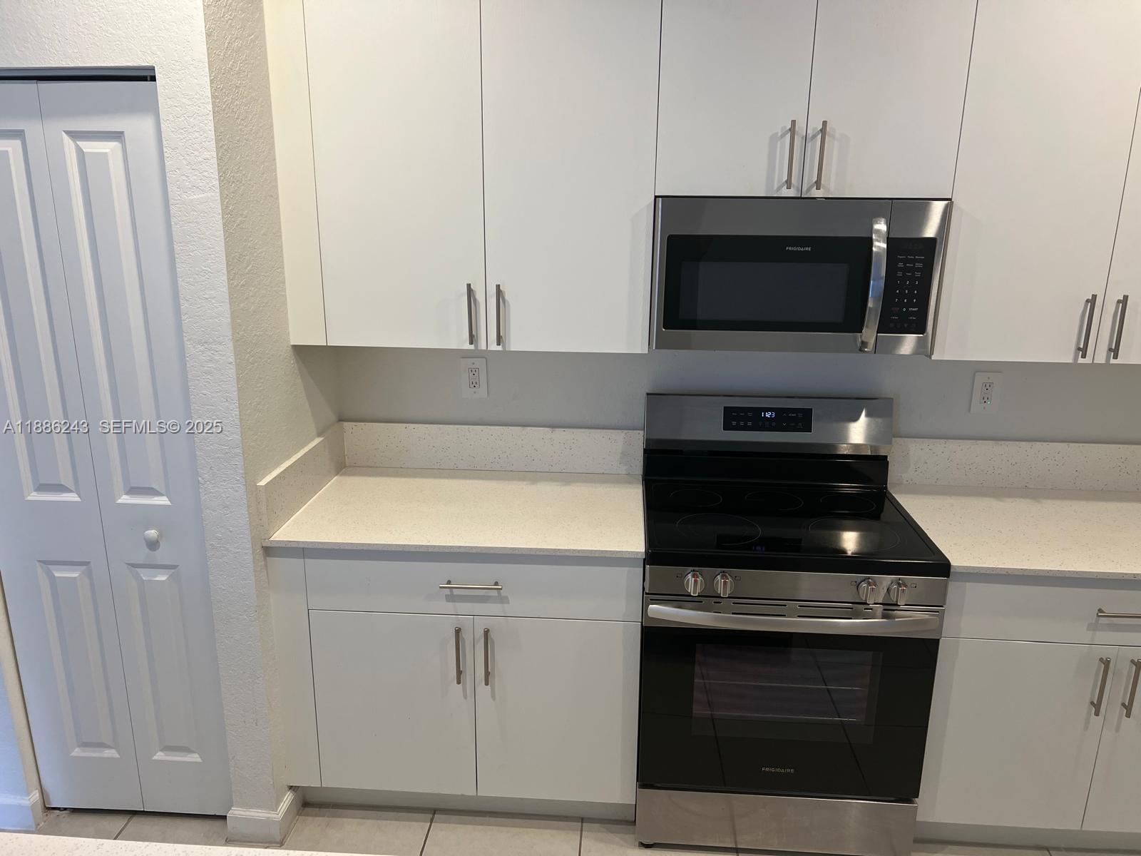 26413 Southwest 149th Avenue, Unit 26413 Homestead, FL 33032 - Photo 10 of 29 a kitchen with stainless steel appliances a stove and a microwave