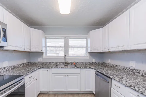 a kitchen with stainless steel appliances granite countertop a refrigerator sink and cabinets